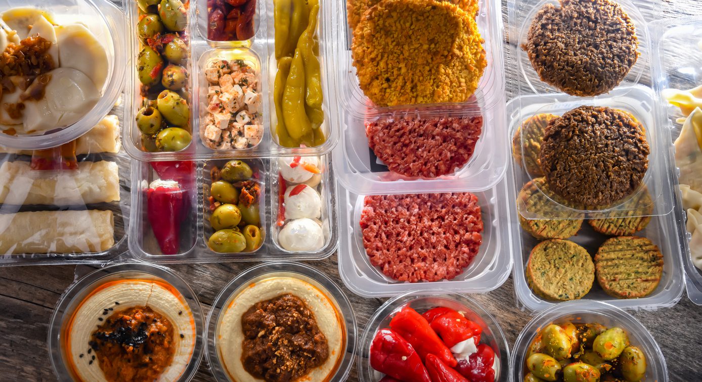 A display of variety of prepackaged food products in plastic boxes.